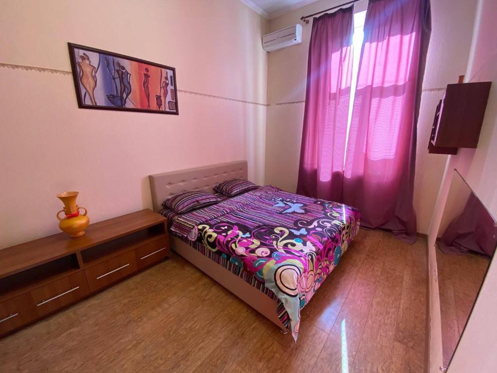 キーウにあるKievAcccommodation near Gulliver 24h Self Check-inの小さなベッドルーム(ベッド1台、紫のカーテン付)