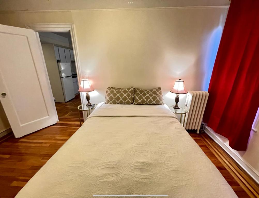 a bedroom with a large bed with two lamps at The Manhattan Central Park Times Square Stays in New York