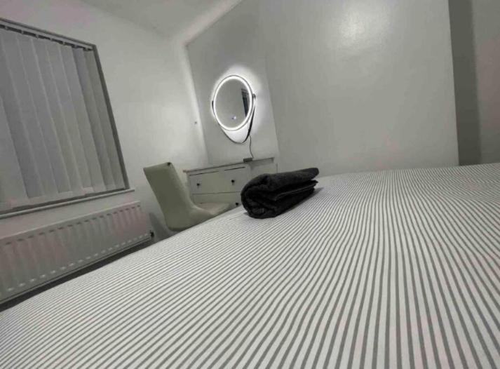 Un dormitorio con una cama con una bolsa negra. en The NEW! 1 Bedroom London House with Garden and Lawn en Londres