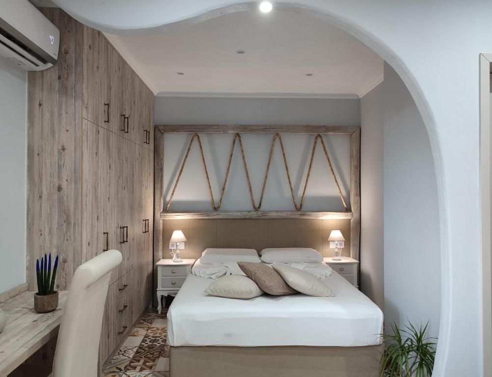 a bedroom with a large white bed and two tables at VILLA KALDERA in Skiathos Town
