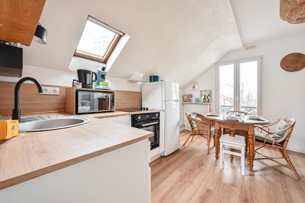 une cuisine avec une table et une salle à manger dans l'établissement Le Splendide - Paris - Métro - 4 personnes, aux Lilas