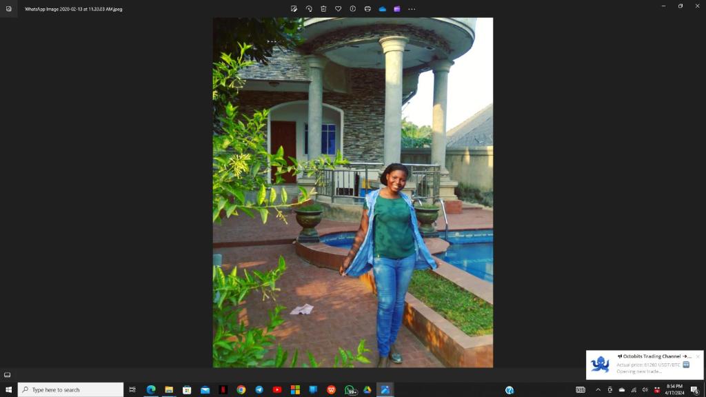 Una donna è in piedi davanti a una casa di Vincent Anene Estate, Nri a Amobia