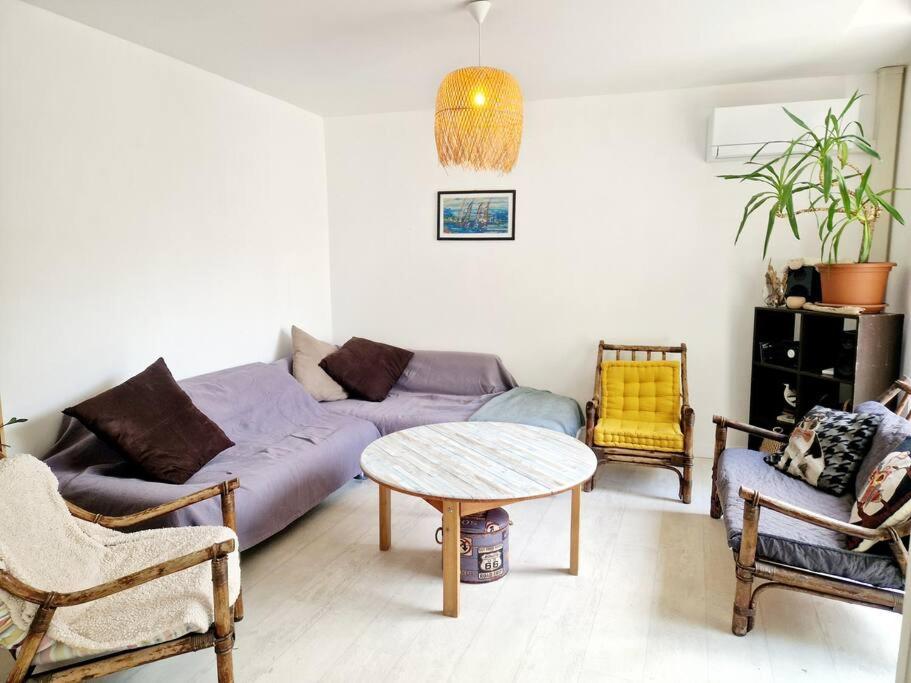 a living room with a couch and a table at Les Pierres Bleues YourHostHelper in Cherbourg en Cotentin