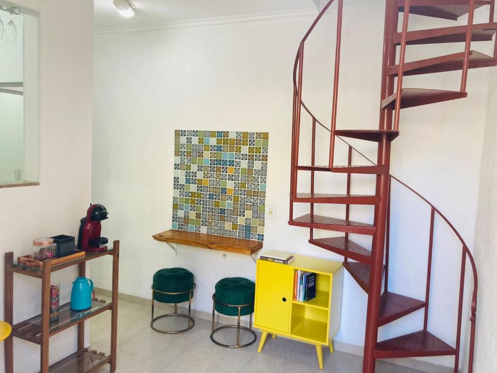 a room with a spiral staircase and two stools at Casa Charmosa in Taubaté