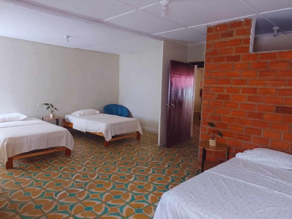 Habitación de hotel con 2 camas y pared de ladrillo en hotel Suyay Lodge Tarapoto, en Tarapoto