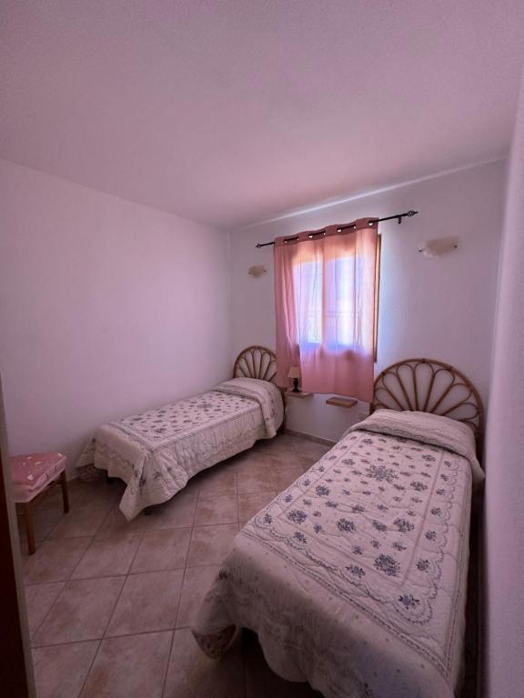 a room with two beds and a window at Il Girasole casa vacanze in Porto San Paolo