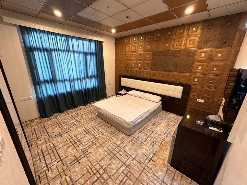 um quarto com uma cama num quarto com uma janela em Athena Stars Hotel em Erbil