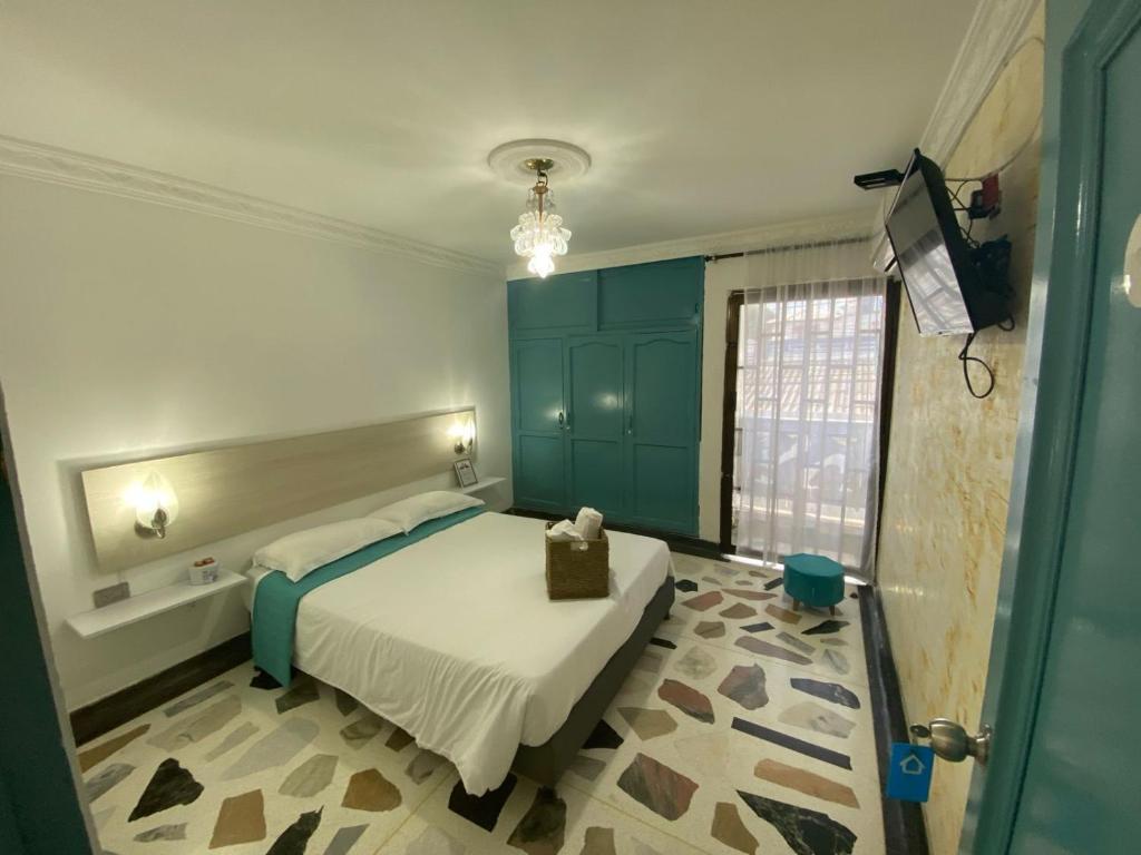1 dormitorio con cama, armarios azules y ventana en Casa Mirtha, en Ríohacha