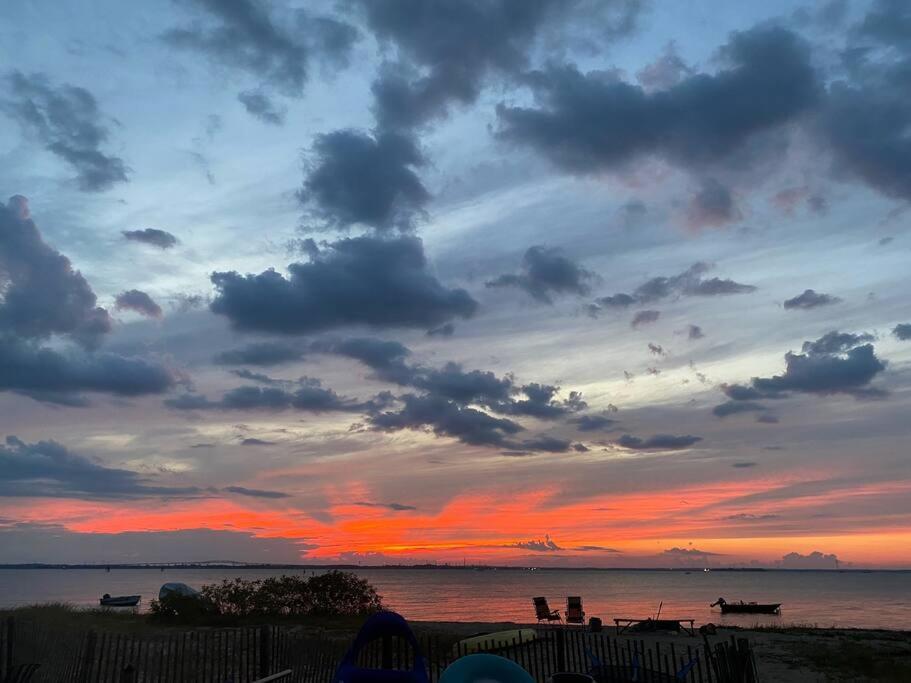 - un coucher de soleil sur la plage avec un ciel nuageux dans l'établissement Beachfront Sunsets At Oakwood Beach, à Delaware City