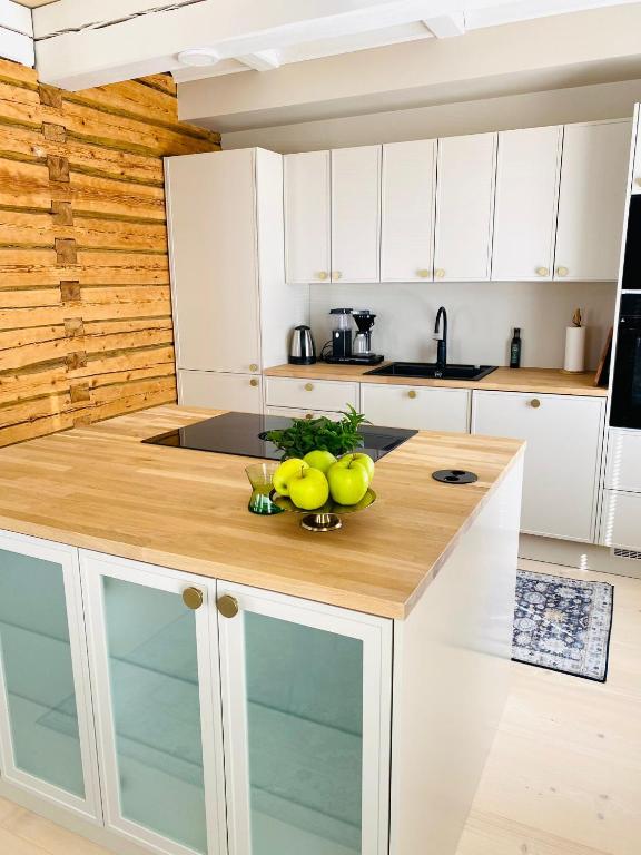 una cocina con armarios blancos y una barra con fruta. en KokkolaDream - Historical Timber Home en Kokkola