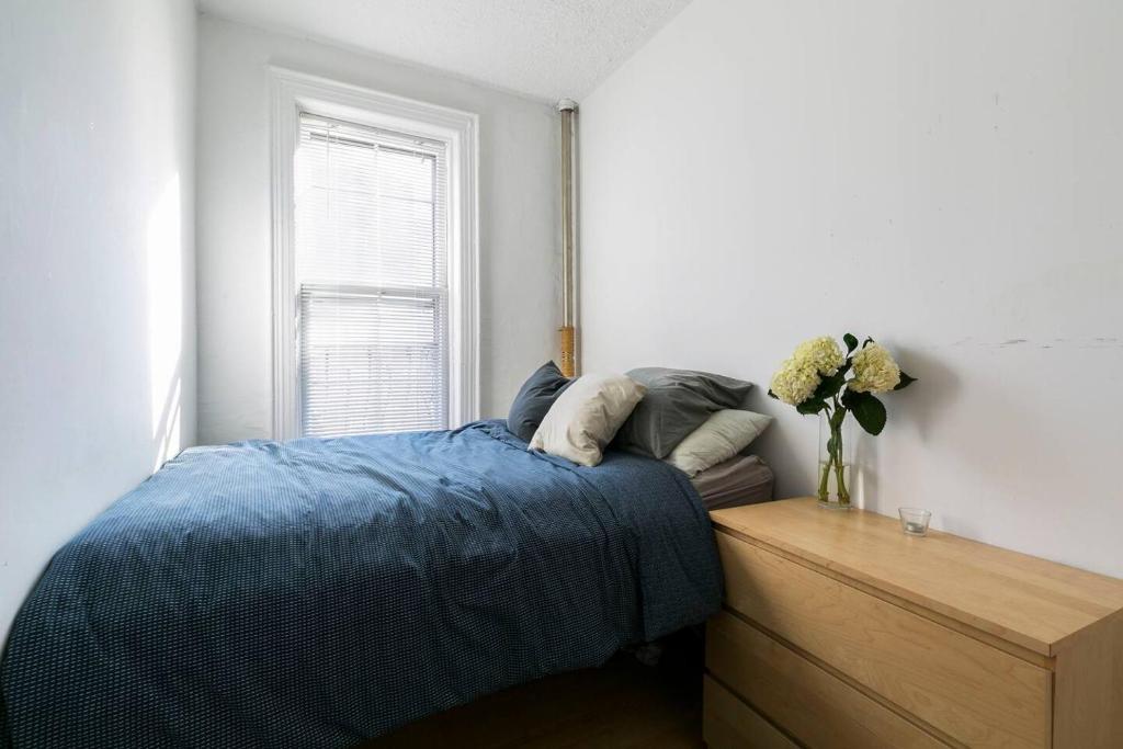 a bedroom with a bed and a vase of flowers at Sundrenched East Village Apartment in New York