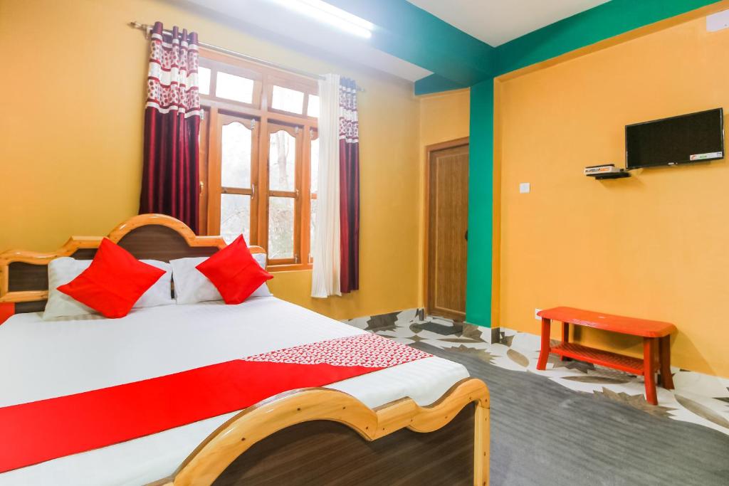 a bedroom with a bed and a tv on the wall at Flagship Jwajalapa Homestay in Kalimpong