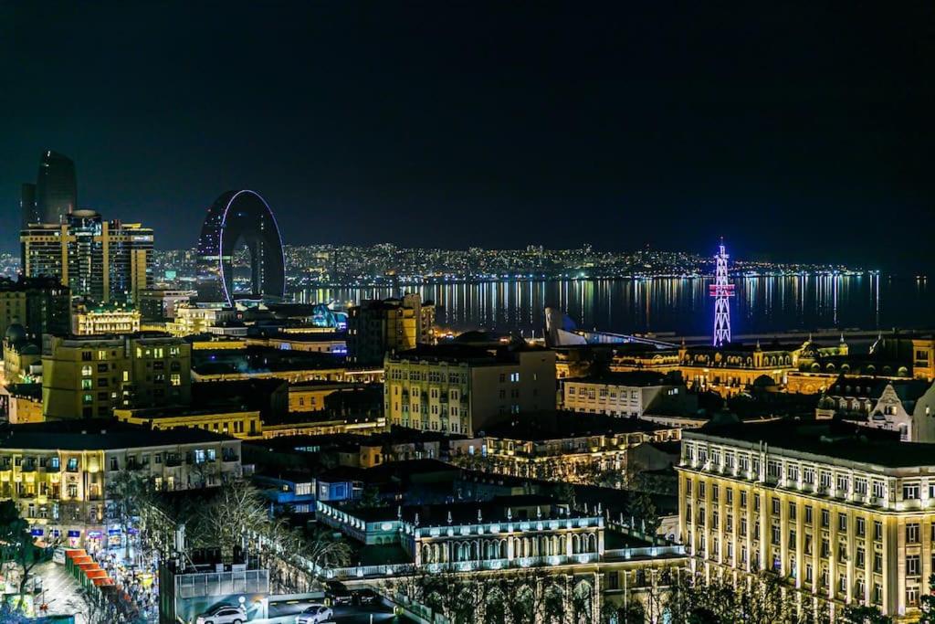 um horizonte da cidade à noite com o olho de Londres em City Centre DeLuxe em Baku