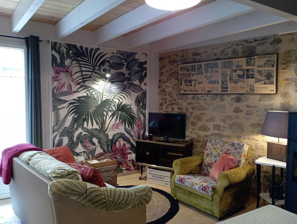 sala de estar con 2 sillas y TV en Charmant gîte à la campagne, proche du Puy du Fou, Les Charmes de Castellariis, en Pouzauges