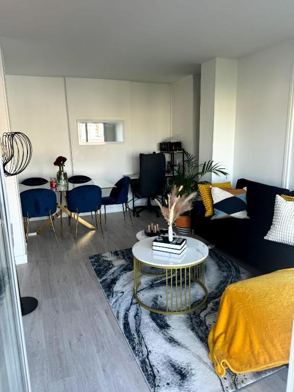 un salon avec un canapé et une table dans l'établissement Chambre privée ds Appartement Design et Confort refait à neuf PROCHE de PARIS, la DEFENSE et VERSAILLES, à Rueil-Malmaison