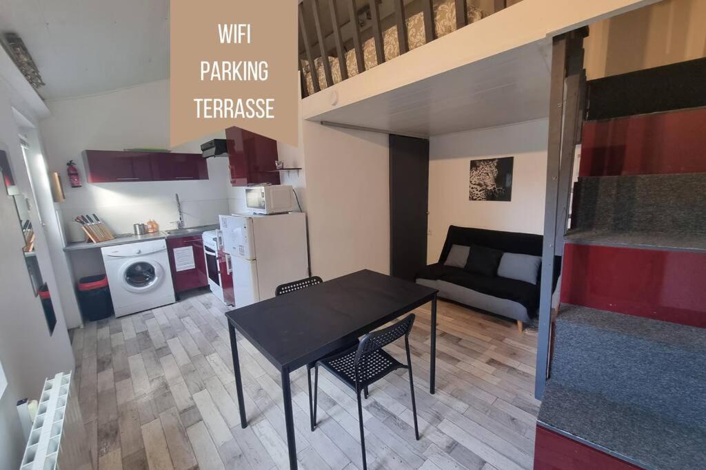 um pequeno quarto com uma mesa de jantar e uma cozinha em Le Guichard - Wifi - Parking - Terrasse em Clermont-Ferrand
