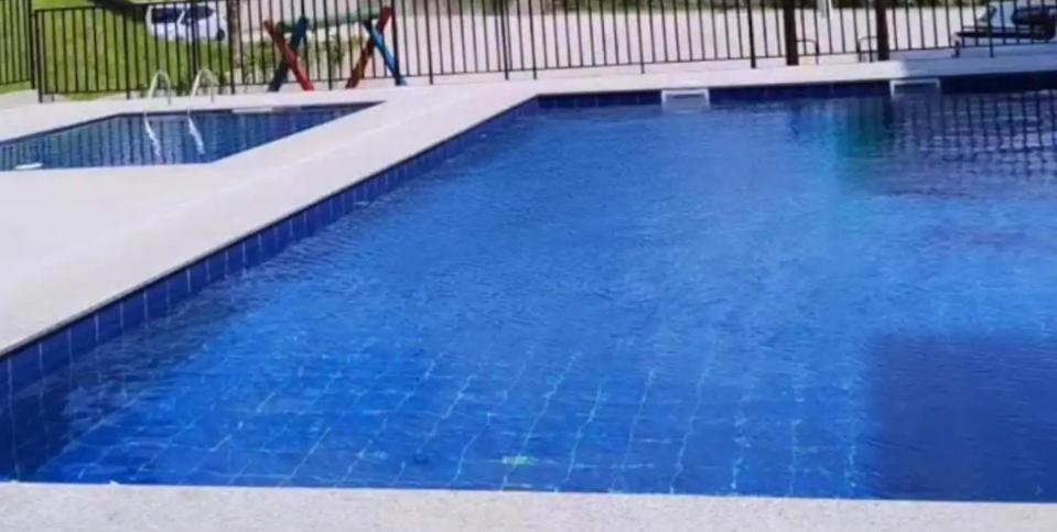 uma grande piscina com água azul em Quarto privado em Florianópolis