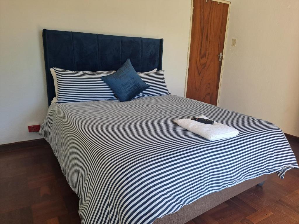 1 cama con edredón de rayas blanco y negro en Excel North Accommodation, en Ciudad del Cabo