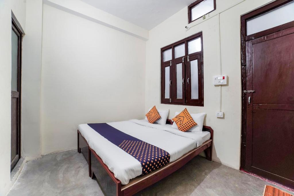 a bedroom with a bed and a wooden door at Super OYO SPOT ON Hotel Aina in Rānīkhet
