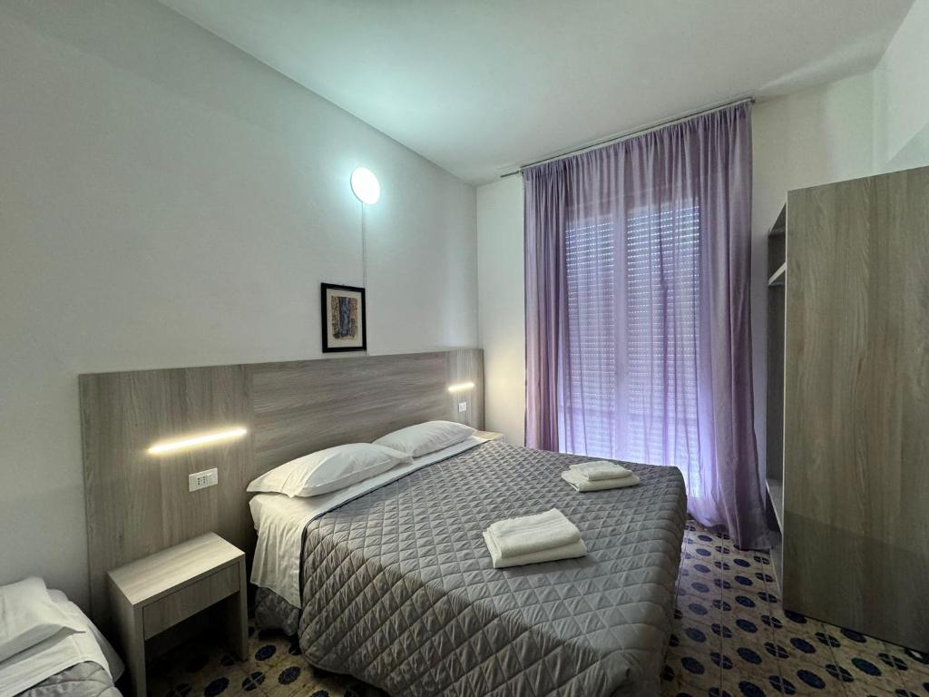 a hotel room with a bed with two towels on it at Hotel Stradiot in Rimini