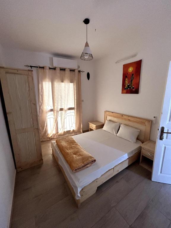 a bedroom with a bed and a large window at Chambre tout confort avec salle de bain intérieure privée - Clim & breakfast in Saint-Louis
