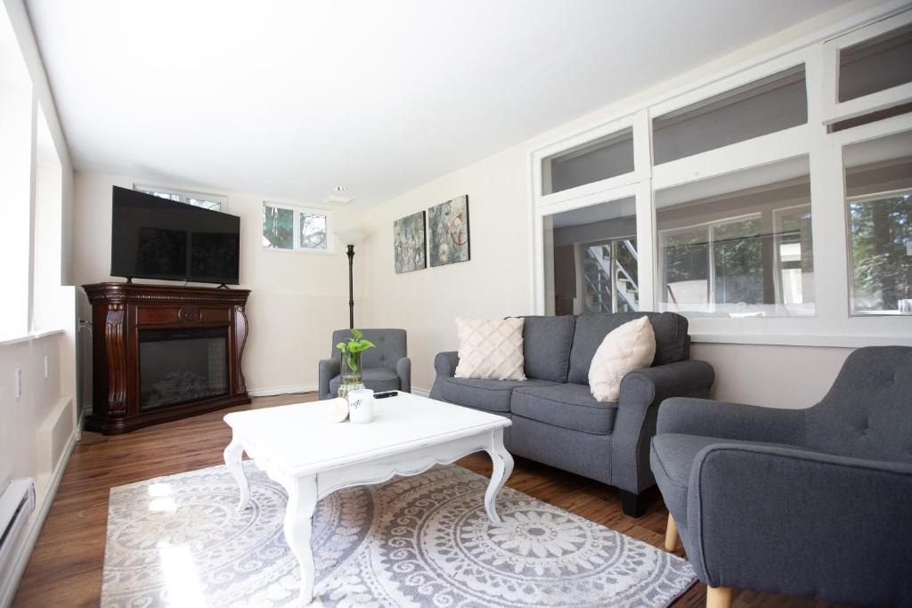 - un salon avec un canapé et une table dans l'établissement Private Garden-Level Suite, à West Vancouver