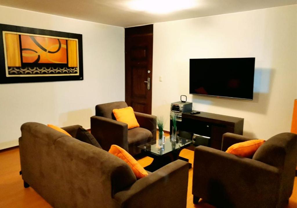 un soggiorno con 2 sedie e una TV di Dpto Amoblado en San Miguel 2 a Lima