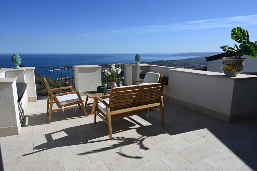 um pátio com uma mesa e cadeiras numa varanda em Paradisea Rocco's Villa em Taormina
