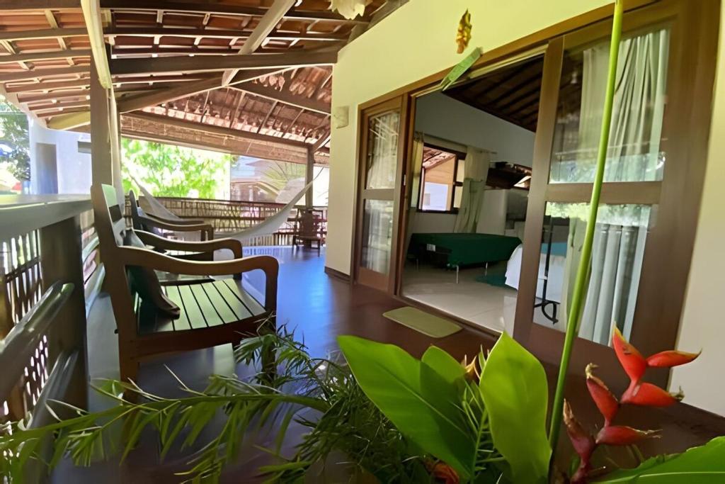 a lobby of a house with chairs and plants at Flat Oxóssi em condomínio beira-mar com varandão cozinha e piscina in Marau