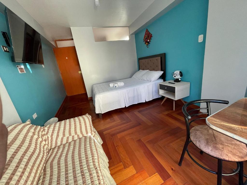 a small room with a bed and a table and a chair at MISKI PUÑUY - Dulces sueños HOSPEDAJE in Cusco