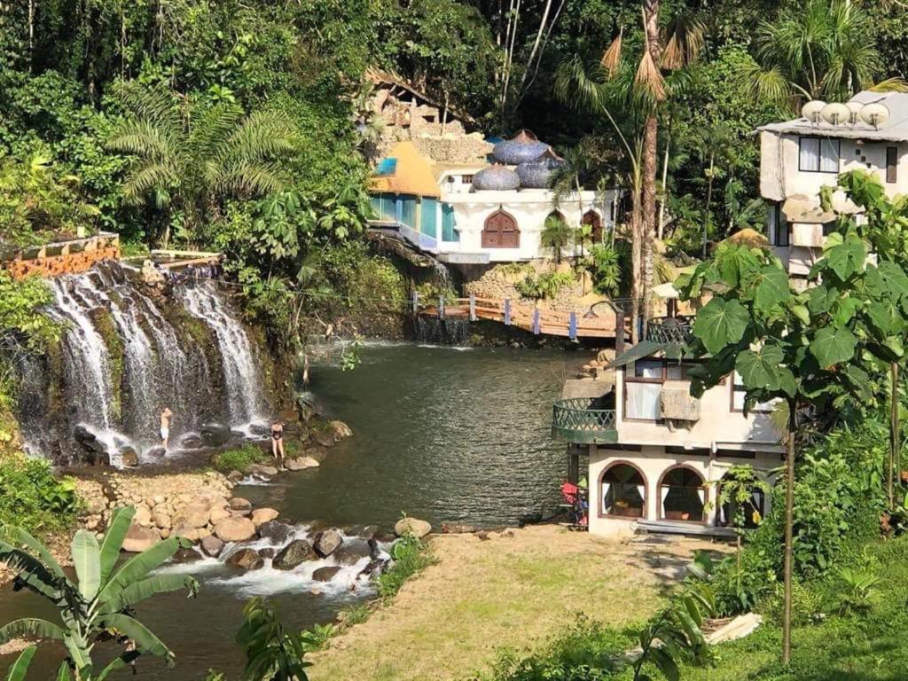 una cascada y una casa junto a un parque acuático en Kashama Eco Resort & Spa, en Santo Domingo de los Colorados