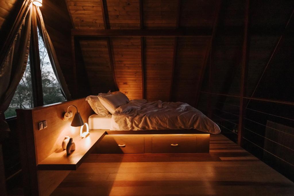 ein Schlafzimmer mit einem Bett in einem Zimmer mit einem Fenster in der Unterkunft O Chalé da Praia in Jaguaruna