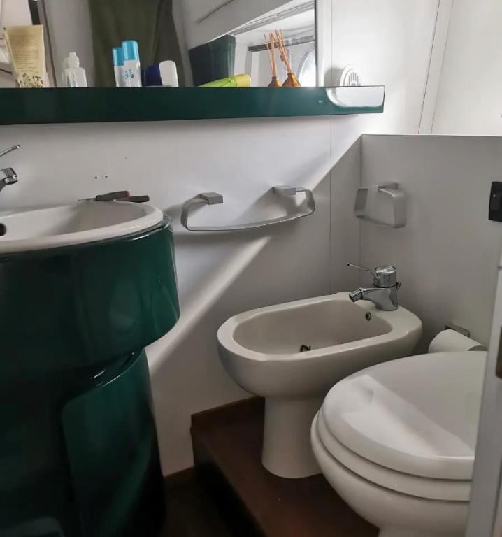 uma casa de banho com um WC branco e um lavatório. em Barca poisedone em Nettuno