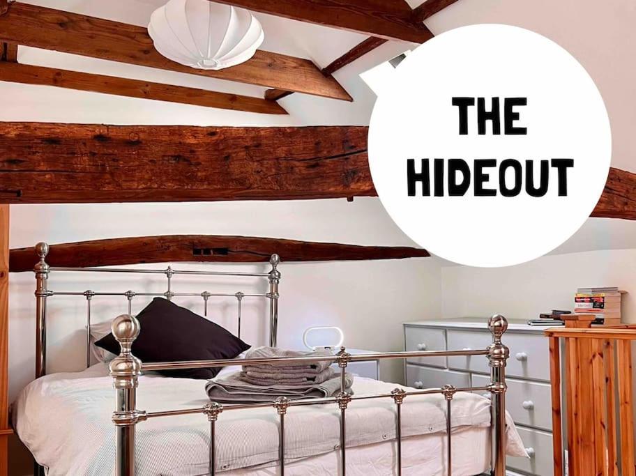 ein Schlafzimmer mit einem Bett mit einem Metallbettrahmen und einem Hogopt-Schild in der Unterkunft The Hideout in Linton
