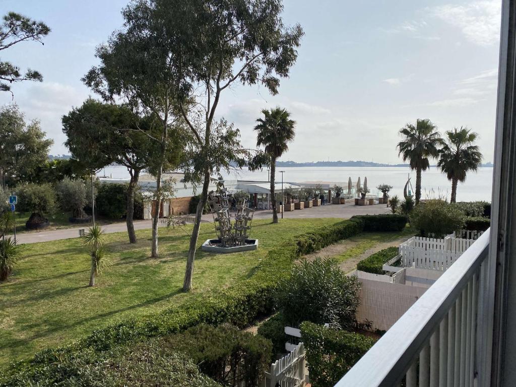 - un balcon donnant sur un parc planté de palmiers dans l'établissement T1 confortable avec balcon et ascenseur à Balaruc-les-Bains - FR-1-553-181, à Balaruc-les-Bains