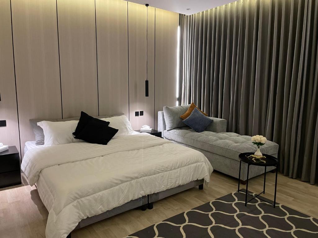 um quarto com uma cama e um sofá em LUSSO Studio - استوديو لـوسـو الفندقي em Riade