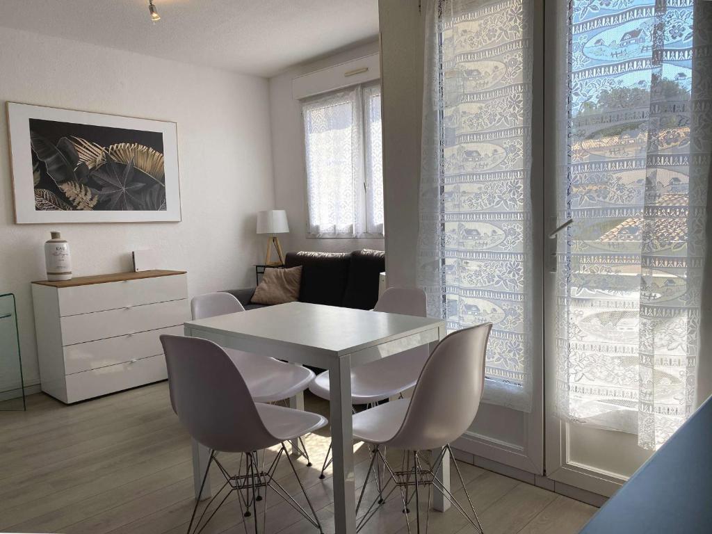 une salle à manger avec une table et des chaises blanches dans l'établissement Appartement Balaruc-les-Bains, 2 pièces, 2 personnes - FR-1-553-183, à Balaruc-les-Bains