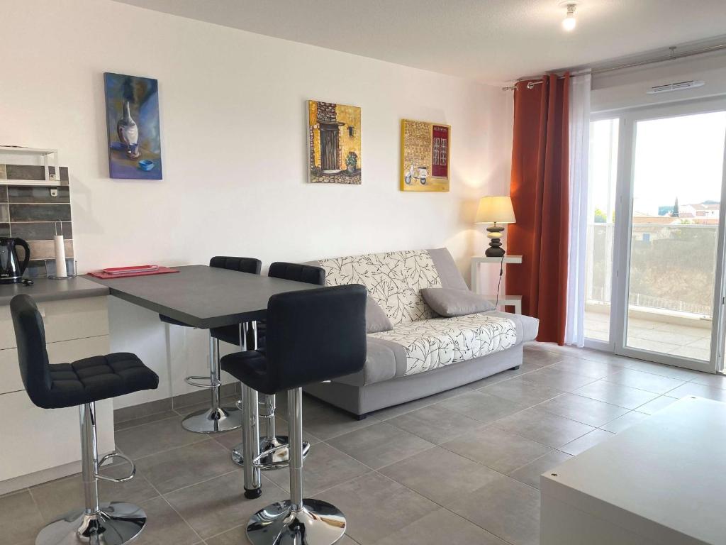 uma sala de estar com um sofá e uma mesa em Appartement Balaruc-les-Bains, 2 pièces, 2 personnes - FR-1-553-204 em Balaruc-les-Bains