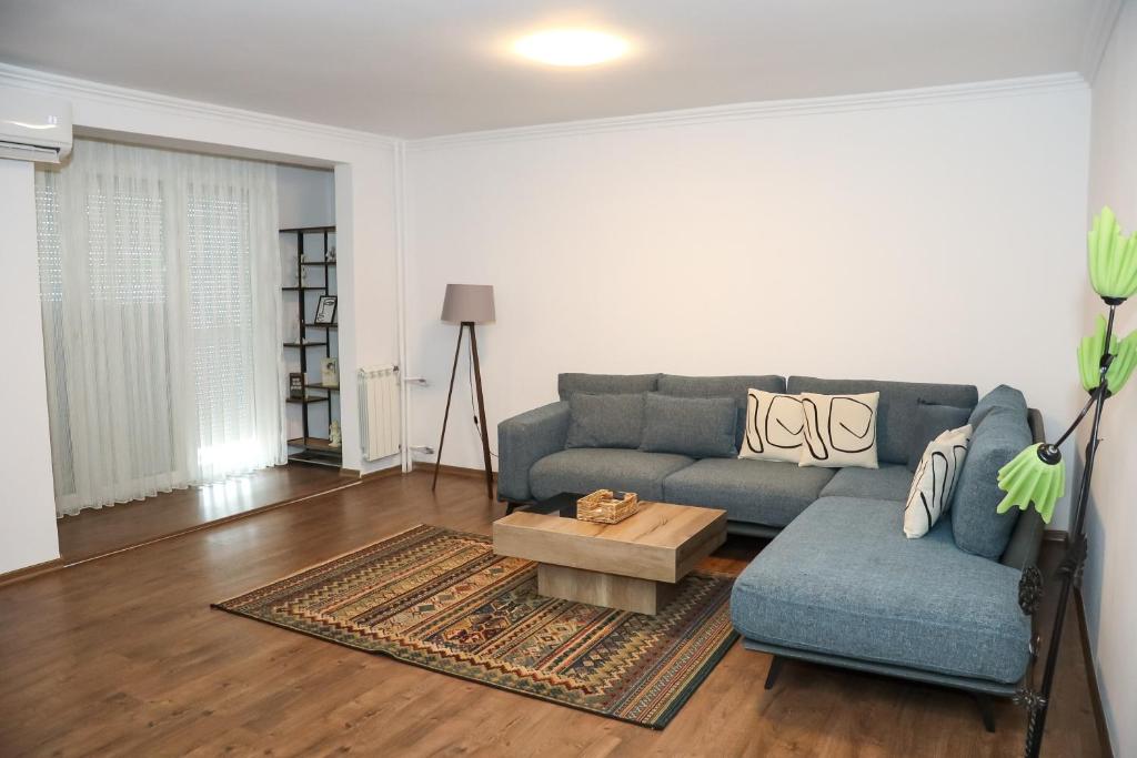 プリシュティナにあるArt Apartmentの青いソファとコーヒーテーブルのあるリビングルーム