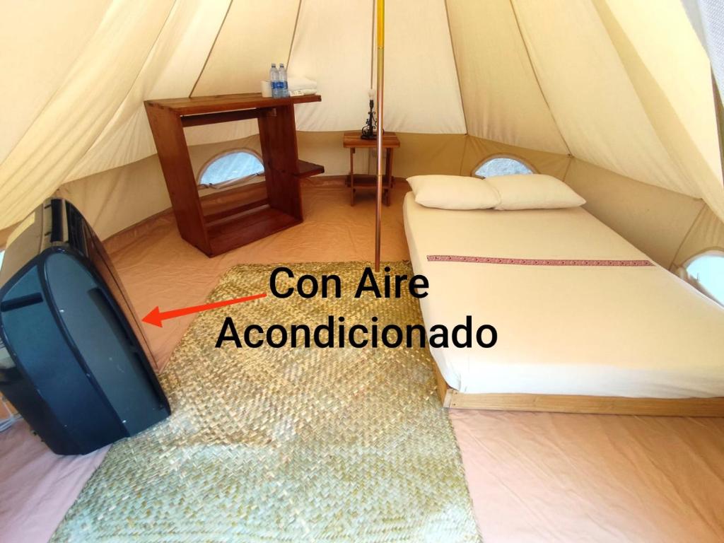a room with a tv and a bed in a tent at Glamping De la Vereda in Cuetzalán del Progreso