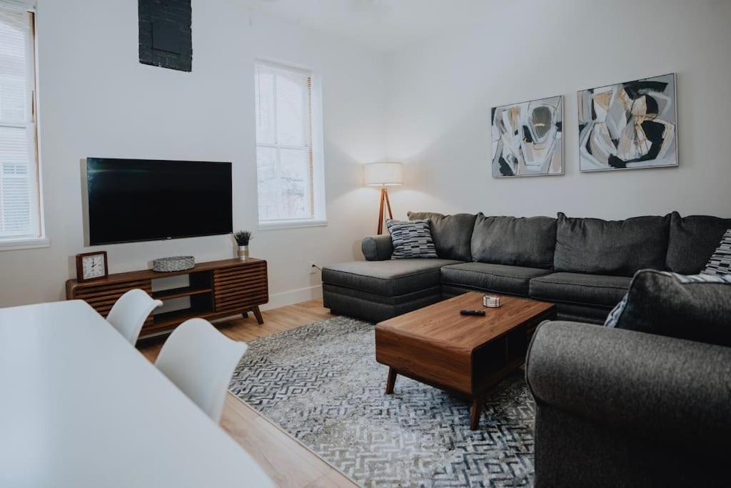 een woonkamer met een bank en een tv bij Urban 4BR-2BA Group Hub-Patio & Games-Soulard in Soulard