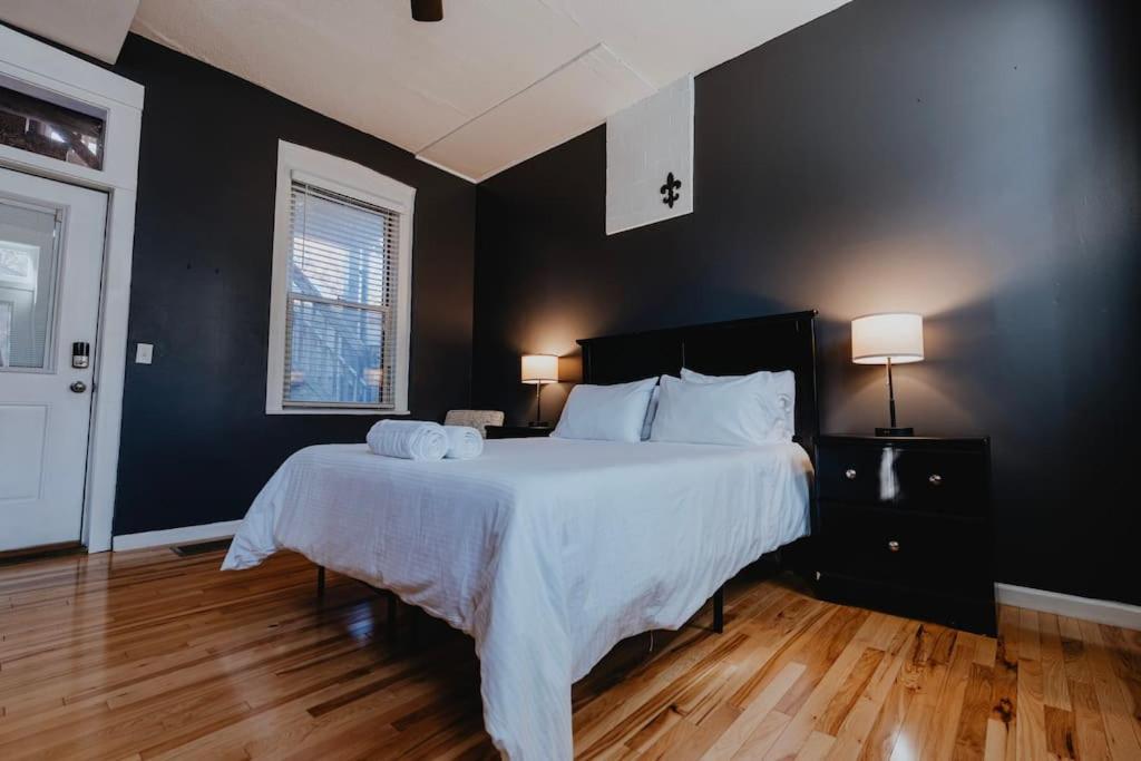 um quarto com uma cama grande e lençóis brancos em Urban Studio WFH Setup & Patio Soulard em Soulard