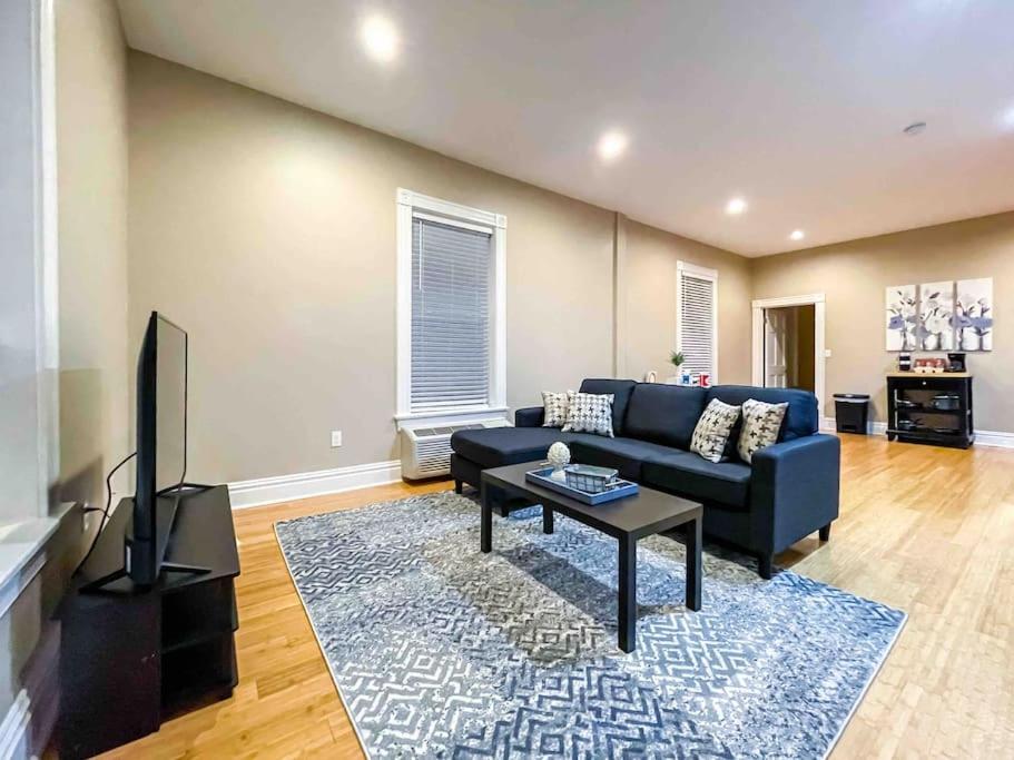 a living room with a blue couch and a tv at Modern 1BR-1BA Monthly Rental The Hill in Tower Grove