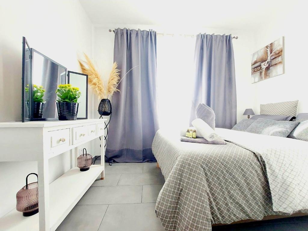 Un dormitorio con una cama y una cómoda con espejo. en Un havre de paix les pieds dans l'eau, en La Seyne-sur-Mer