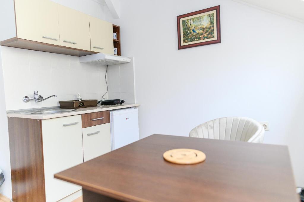 una cucina con tavolo in legno e piano di lavoro di Apartmani Zvirac a Soko Banja