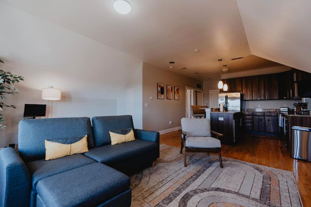 a living room with a blue couch and a kitchen at Modern 1BR-1BA Walk to SSM SLU Hospital Grand in Tower Grove