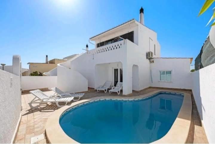 a swimming pool in front of a white house at Casa Serra e Mar in Luz