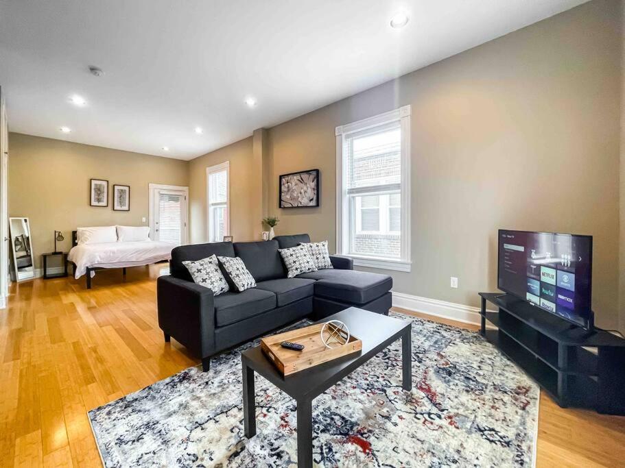 a living room with a couch and a flat screen tv at Modern Studio Full Kitchen & Balcony The Hill in Tower Grove