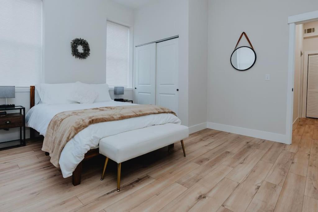 1 dormitorio blanco con 1 cama grande y suelo de madera en Spacious 2BR-2BA Patio & Games Soulard, en Soulard
