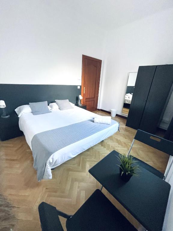 - une chambre avec un grand lit et une table dans l'établissement Ibiza habitaciones, à Madrid